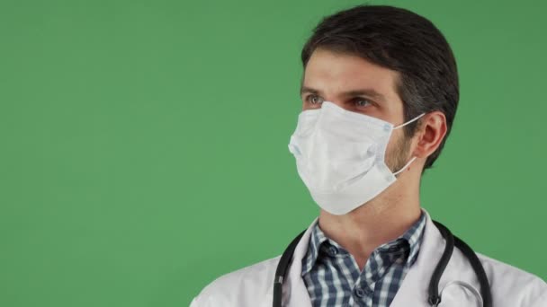 Cheerful male doctor in a medical mask smiling to the camera - Footage, Video