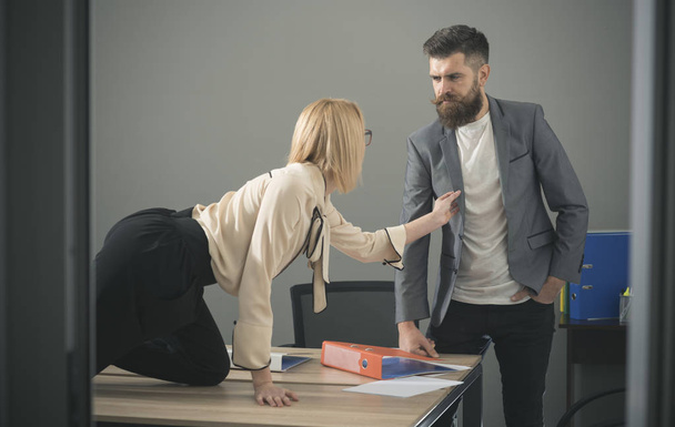Sexy secretary flirting with boss in workplace. Sexual harassment and office abuse concept - Foto, imagen