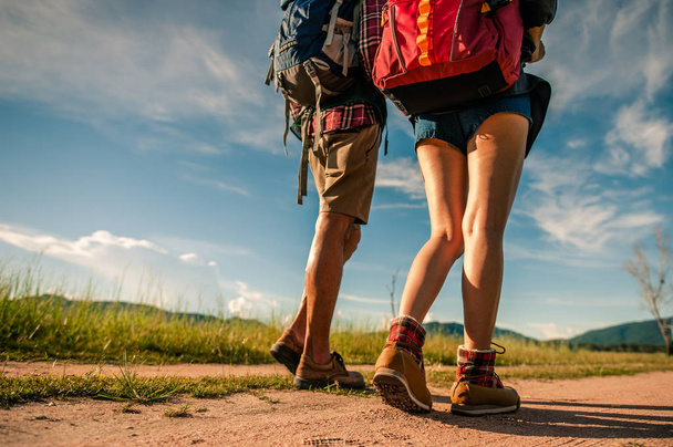 Hikers with backpacks walking trough forest path wearing mountain boots with focus on the shoes. - 写真・画像