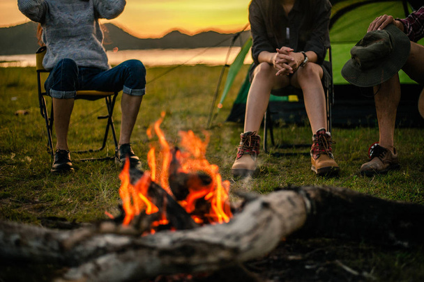 Group of friends camping.They are sitting around fire camp. - Foto, immagini