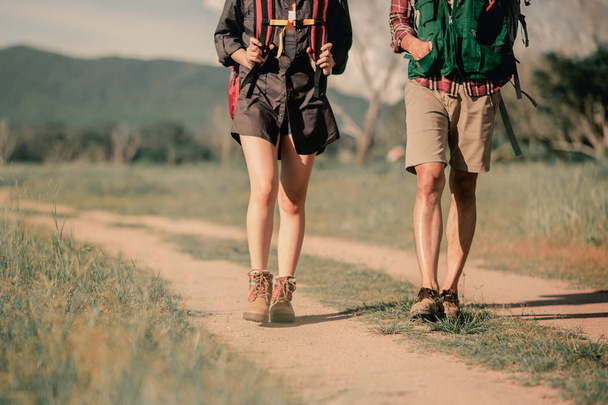 Hikers with backpacks walking trough forest path wearing mountain boots with focus on the shoes. - Foto, Imagem