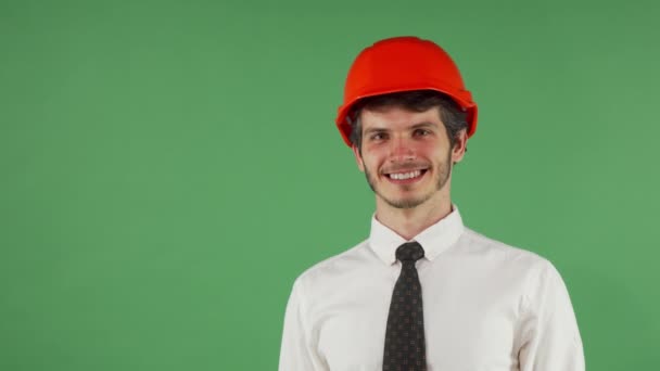 Vrolijke knappe mannelijke ingenieur dragen van veiligheidshelm knipogen naar de camera - Video