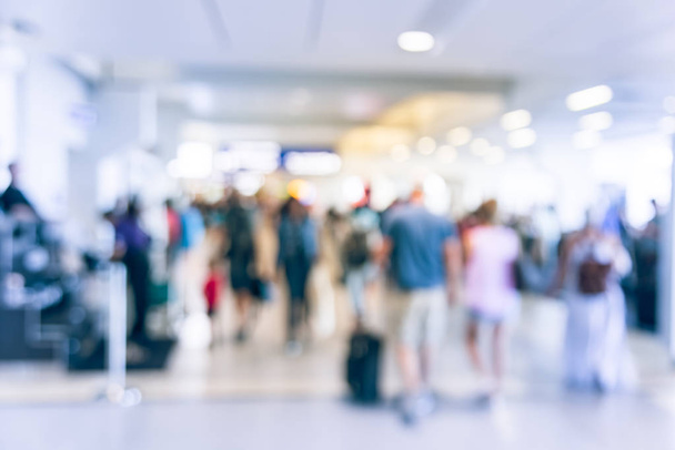 アメリカの空港で荷物を持って歩いてぼやけ動き人々。抽象的なぼやけた乗客やバッグ、背面の観光客。旅行者歩けば廊下ターミナル、輸送の概念をデフォーカス - 写真・画像