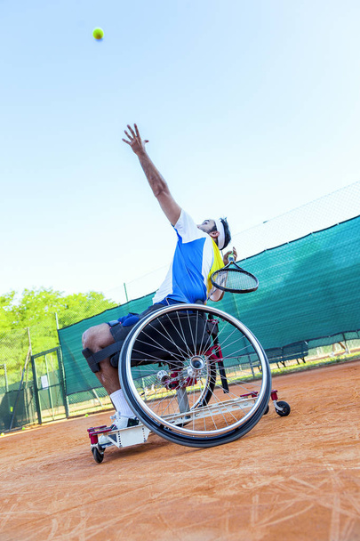 disabled tennis player hits the ball for service during a match outdoor - Fotografie, Obrázek