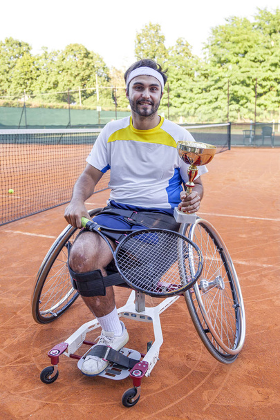 young disabled tennis player shows the cup after winning the outdoor tournament - Fotografie, Obrázek