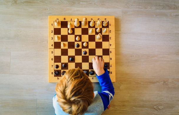 Menino aprendendo a jogar xadrez
 - Foto, Imagem