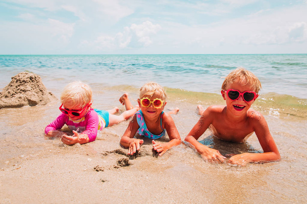 küçük oğlan ve kız sahilde kum ile oynamak - Fotoğraf, Görsel