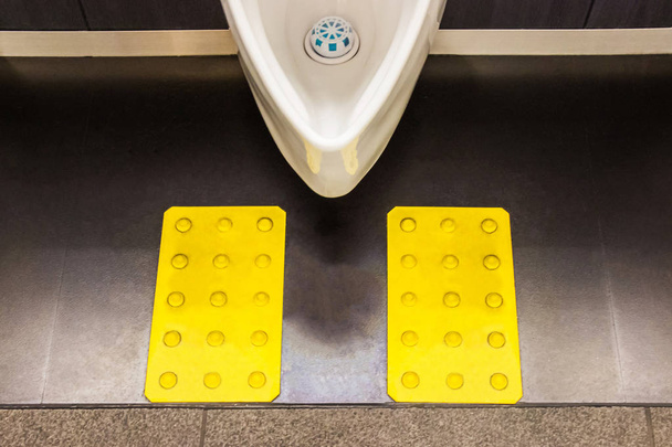 urinóis de cerâmica branca no projeto do banheiro dos homens para deficientes visuais. Japão
 - Foto, Imagem