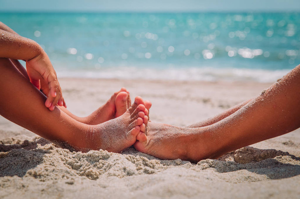 feet of little boy and girl play with sand on beach - Zdjęcie, obraz