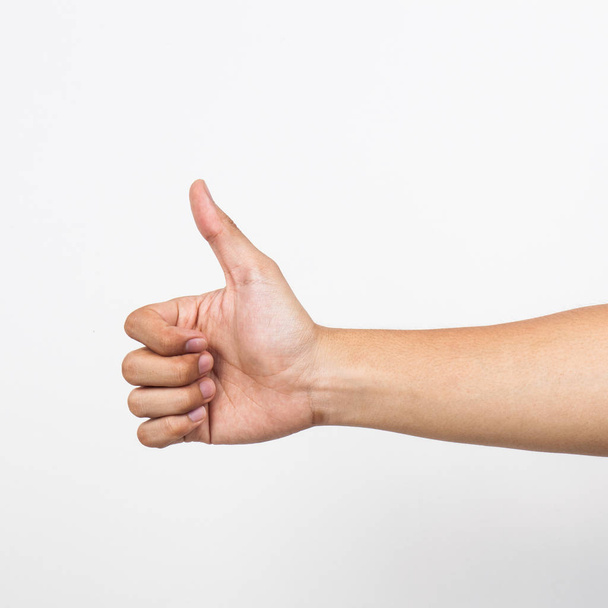 Closeup of male hand showing thumbs up sign against white background - Zdjęcie, obraz