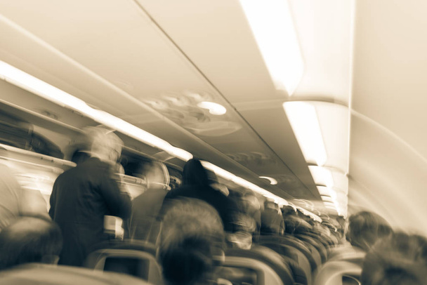 Vintage ton arrière-plan flou intérieur de grand avion avec des gens debout à l'allée en attente de descendre. Siège passager à l'intérieur de l'aéronef. Concept de voyage
 - Photo, image