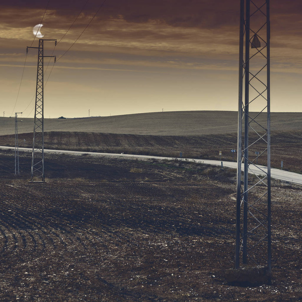 オリーブ グローブと月明かり収穫後スペイン内のフィールド。イベリア半島の風景でパイロンに搭載の電気送電線 - 写真・画像
