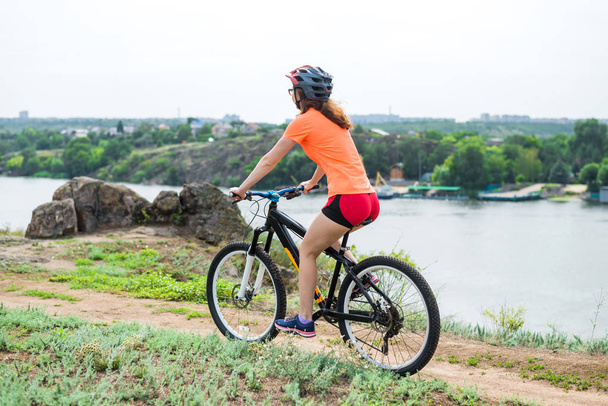 junge Frau auf dem Mountainbike, ein aktiver Lebensstil. Radfahren in der Natur, freier Raum. - Foto, Bild