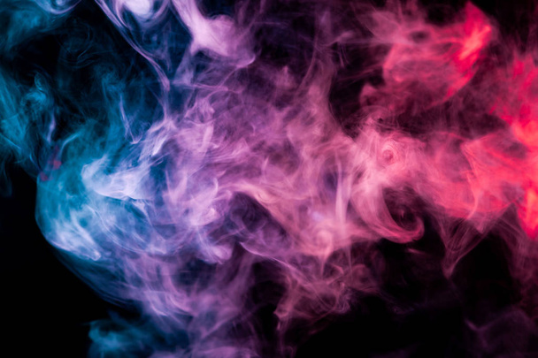 Humo denso multicolor de colores azul, rosa y púrpura sobre un fondo negro aislado. Antecedentes de humo vap
 - Foto, Imagen