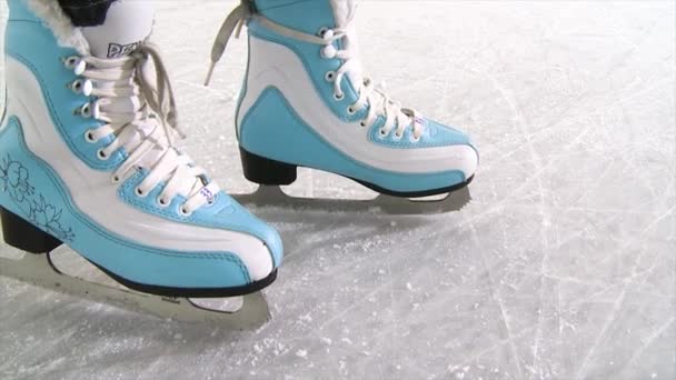 Közelkép a korcsolyát, télen egy korcsolyapálya a női lábak. Jelenet. Nő korcsolyázás közelről - Felvétel, videó