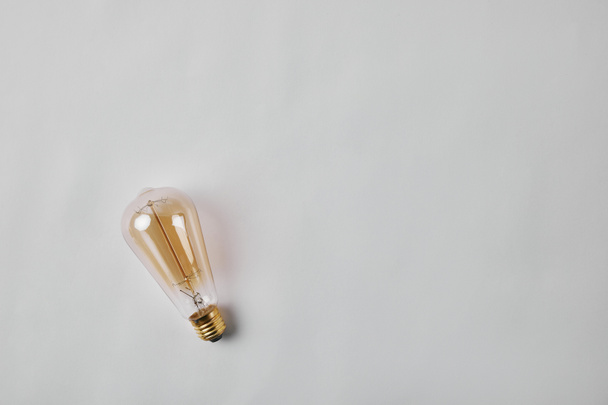 top view of vintage incandescent lamp on white surface - Fotoğraf, Görsel