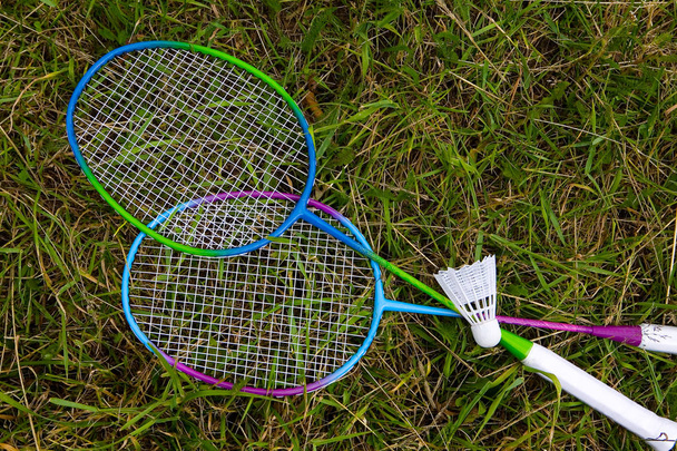 Rackets for badminton and shuttlecock lie on the grass. Sports Equipment. - Zdjęcie, obraz