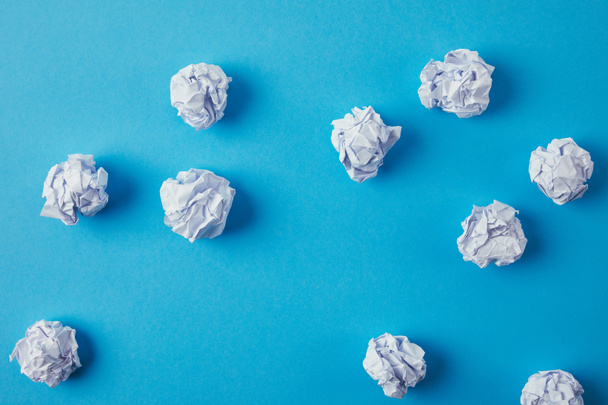 top view of crumpled papers on blue surface - 写真・画像