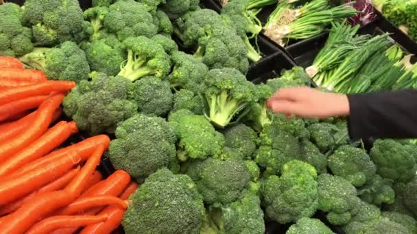 Movimiento de la mujer comprando brócoli dentro de la tienda Save on Foods
 - Metraje, vídeo