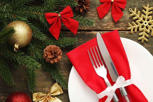 Kitchen cutlery with plate and christmas decorations on wooden table - Foto, immagini