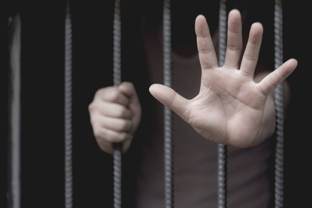 Крупный план на руках человека, сидящего в тюрьме, понятие заключенного, Надежда быть свободным
. - Фото, изображение