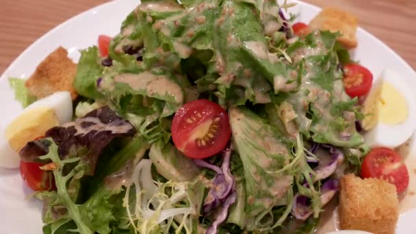 Κίνηση του σουσάμι σαλάτα στο τραπέζι μέσα στο εστιατόριο - Πλάνα, βίντεο