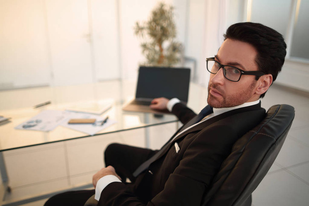 businessman sitting at his Desk and looking at the camera - Фото, изображение