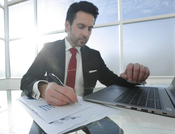 businessman uses a laptop sitting at his Desk - Фото, зображення