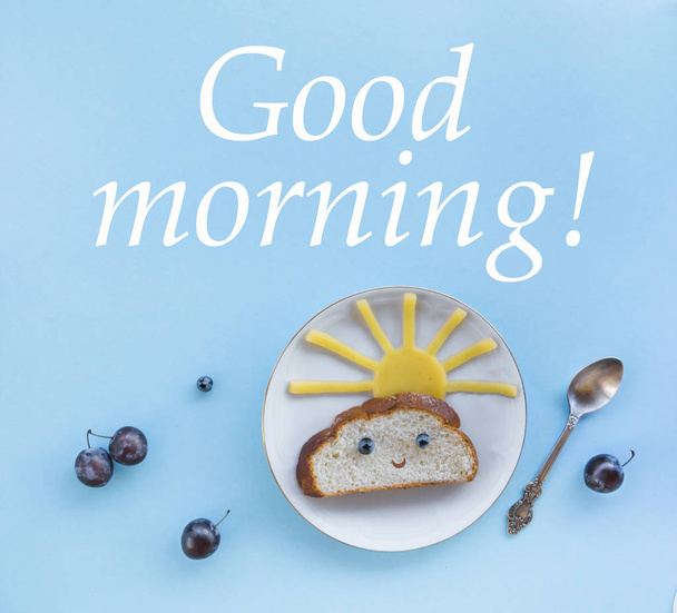 on a blue background breakfast morning sun cloud sky rays rays cute sandwich healthy food berries blueberries plum bread cheese plate spoon serving - Foto, afbeelding