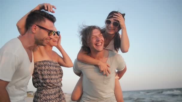 Portret van gelukkige jonge groep mensen genieten van strandvakantie. Vier vrienden zijn lachend in de buurt van de zee tijdens zomertijd. - Video