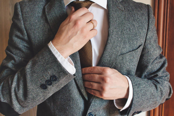 Hombre en traje inteligente con anillo de boda ajuste de corbata
 - Foto, imagen