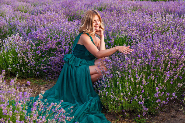 Young girl in green dress posing on lavender field - Zdjęcie, obraz
