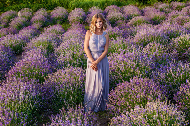 Young girl in purple dress posing on lavender field - Fotoğraf, Görsel