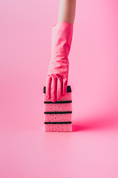 cropped image of woman in rubber glove holding stack of washing sponges, pink background  - Foto, Imagem