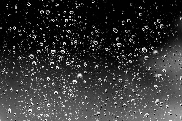 Regendruppels op zwart glas - Foto, afbeelding