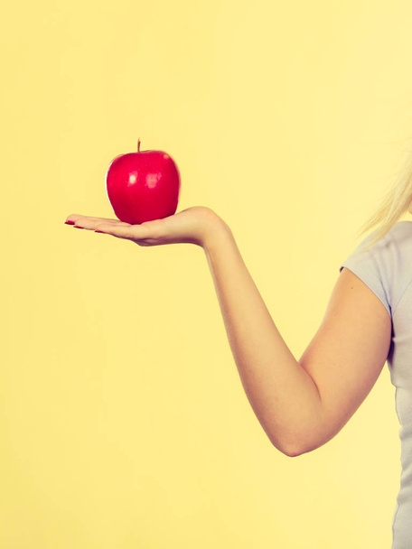 Fruits, food, source of vitamins, good healthy nutrition concept. Woman hand holding delicious red apple - Foto, Bild