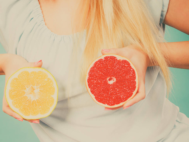 Healthy diet, refreshing food full of vitamins. Woman holding sweet delicious citrus fruit, red and green grapefruit. - Foto, immagini