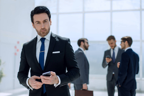 businessman with a smartphone on background office - Foto, Imagem