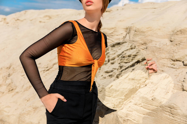 砂丘砂の反射ミラーを保持している黒の流行の服で女性のビューをトリミング - 写真・画像