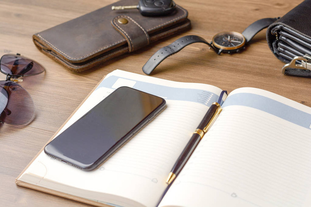 Men's accessories - a purse, glasses, a bag, a business card, a clock, car keys, a phone, a tablet, a notebook and a pen on the office desk. Business and finance. Lifestyle and fashion. - Φωτογραφία, εικόνα