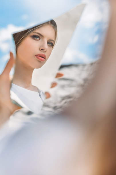 beautiful stylish girl holding piece of mirror and looking on her reflection - Photo, image