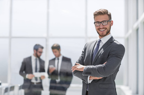 smiling businessman on blurred office background - 写真・画像