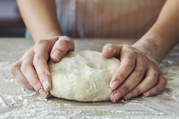 Les mains féminines pétrissent la pâte
 - Photo, image