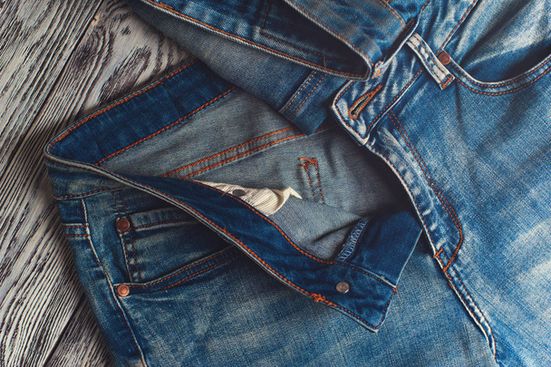 Blue denim jeans on wooden table - Valokuva, kuva