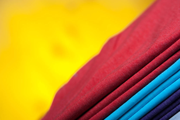 Stack of different cotton t-shirts on wooden table - Fotó, kép
