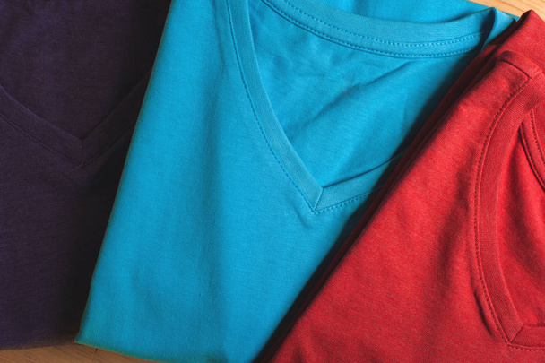Colorful cotton t-shirts, top view - Фото, изображение