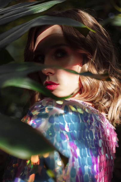 young beautiful fashion model. woman in sequin dress. girl in holographic t-shirt. tropical glamour portrait - 写真・画像