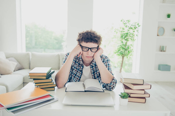 Handsome curly-haired tired young guy student at home, nerd, wearing casual, glasses, studying - Foto, imagen