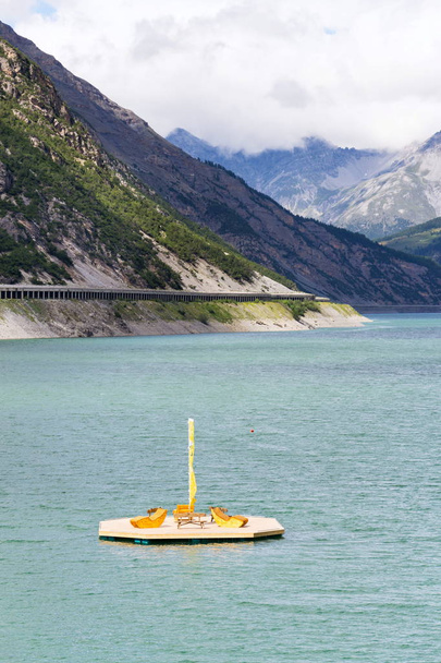 Piękne drewniane molo z ławki i leżaki na Lago di Livigno, Livigno, Włochy, słoneczny letni dzień - Zdjęcie, obraz