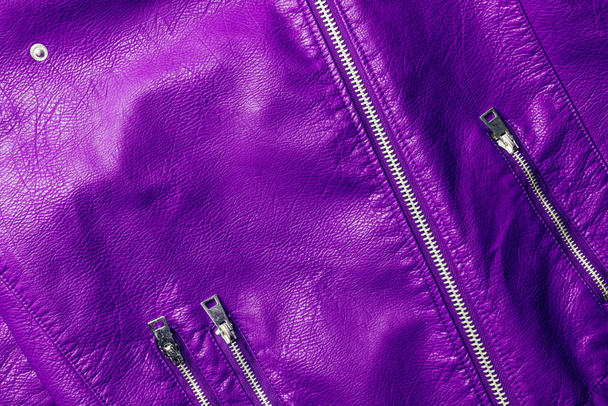 top view of violet leather shiny textile with zippers as background  - Фото, изображение